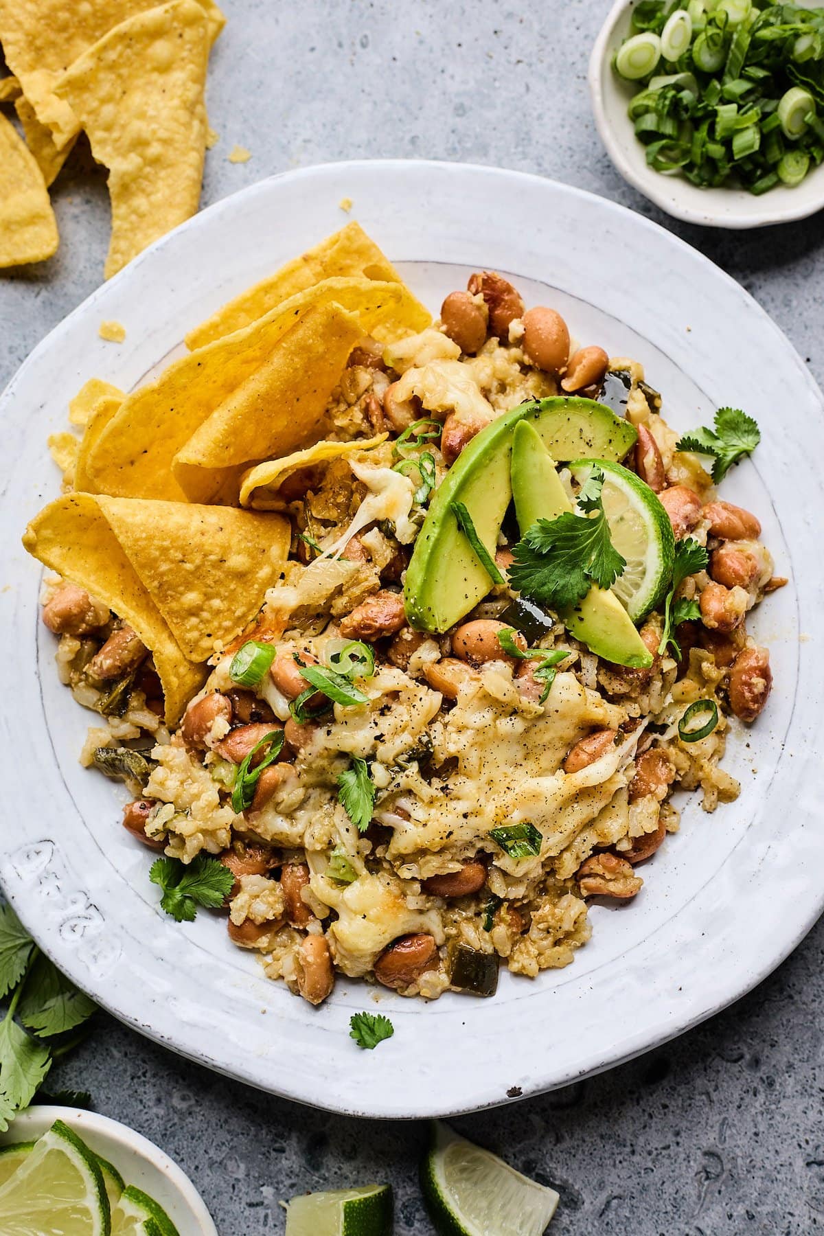 cheesy rice and beans on plate with tortilla chips.
