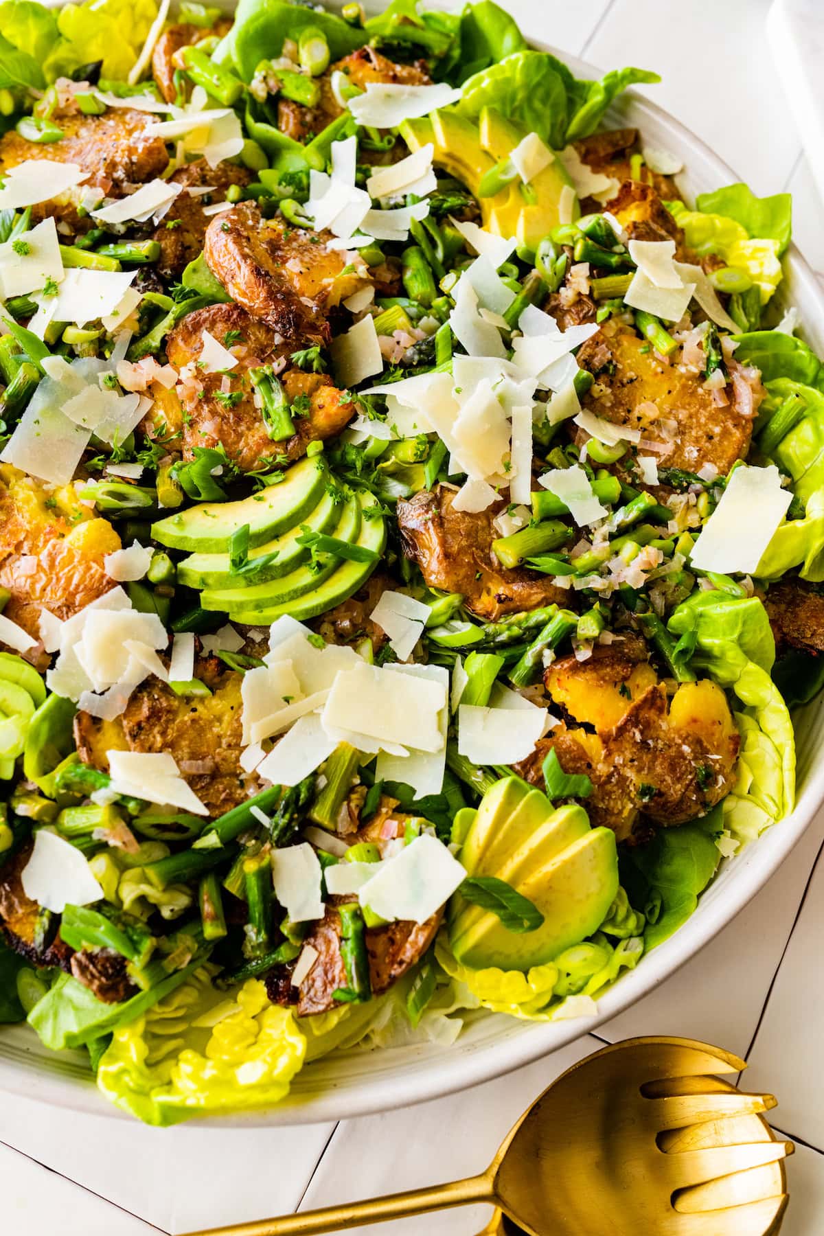 smashed potato spring salad with avocado, asparagus, green onion, and shaved Parmesan cheese.