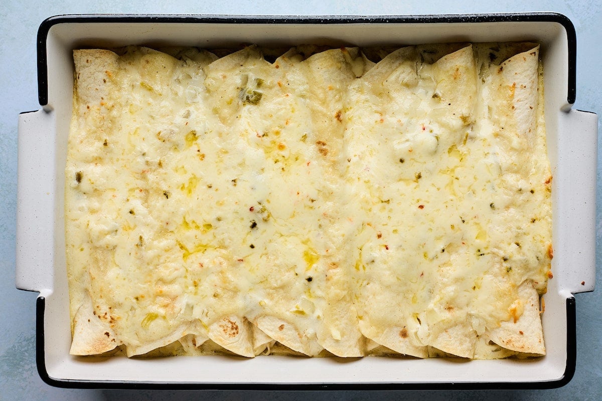 cheesy white chicken enchiladas in pan.