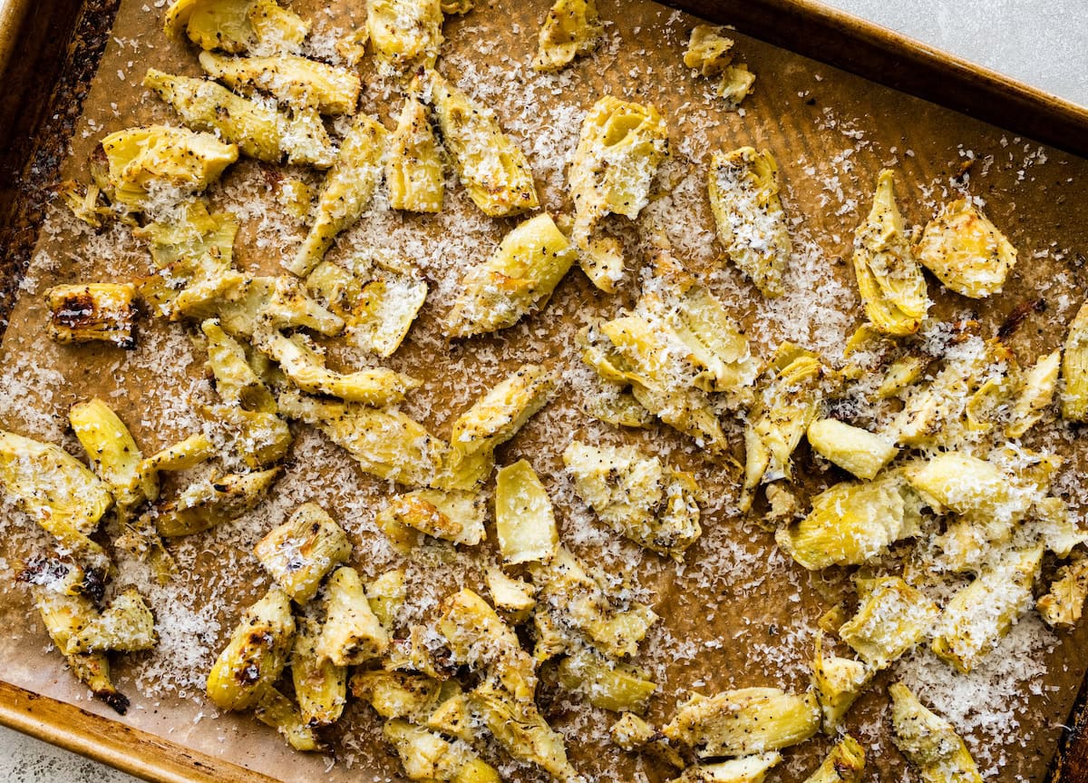 roasted artichoke hearts with parmesan cheese on baking sheet.