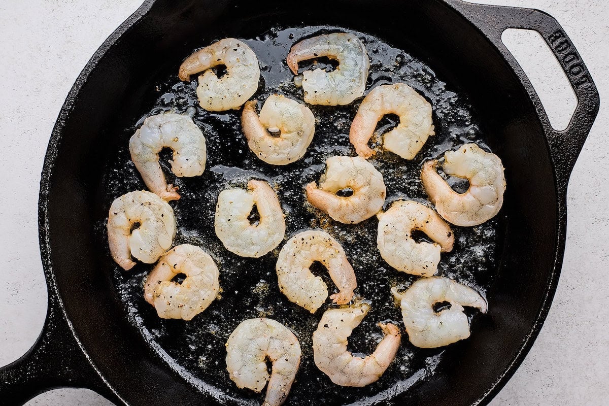 shrimp cooking in cast iron skillet.