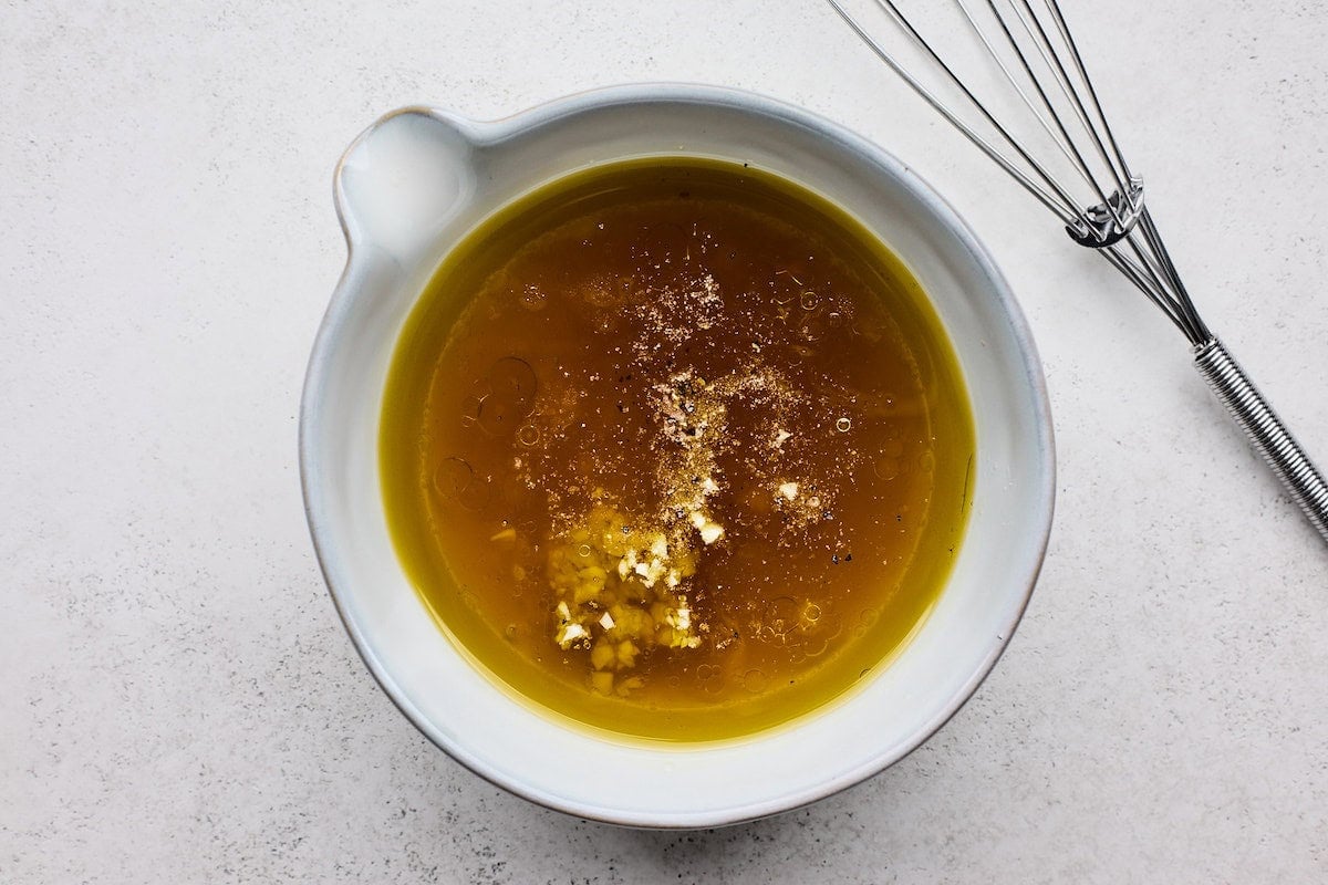 salad dressing in bowl to make shrimp orzo salad.