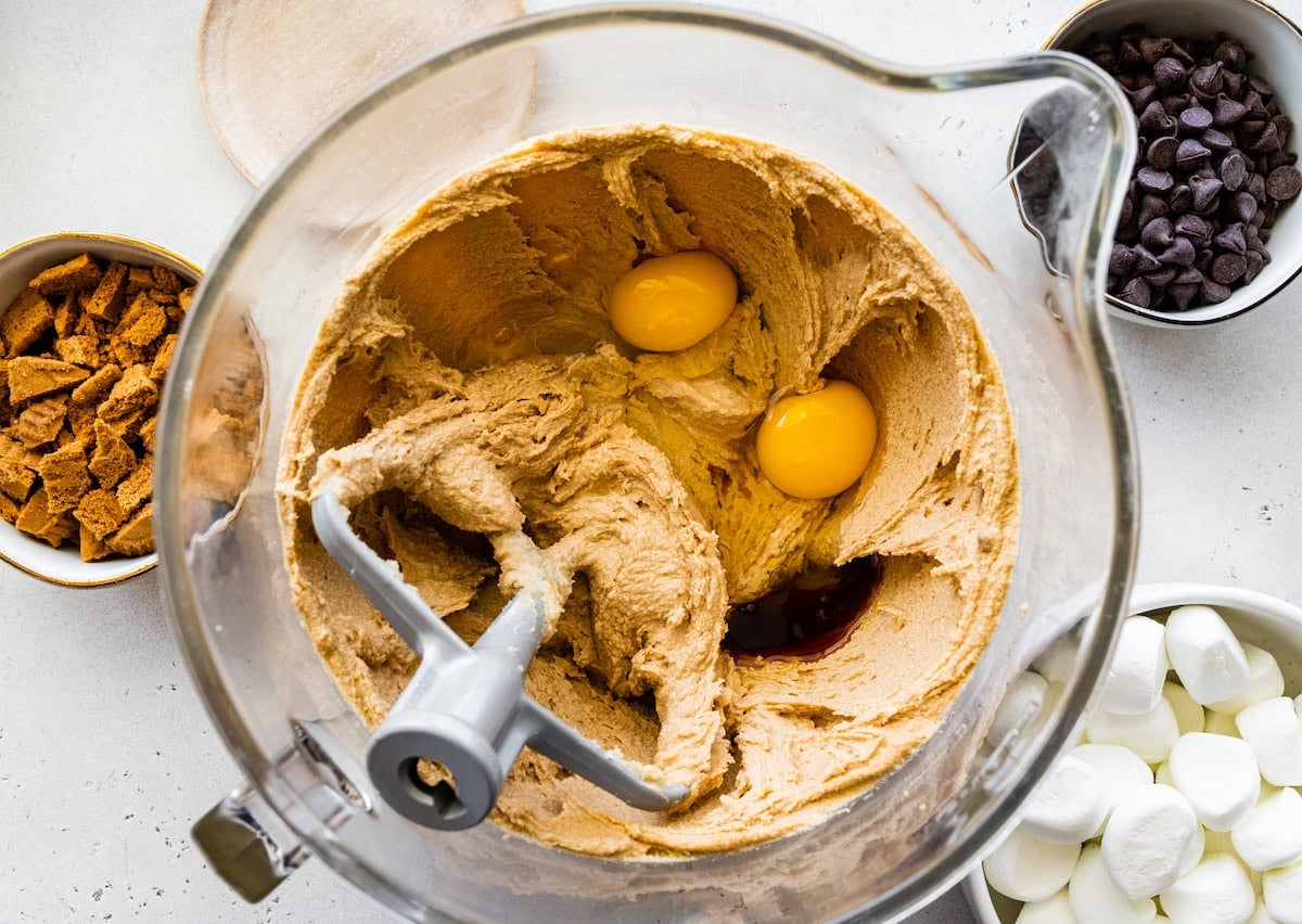 butter, sugars, eggs, and vanilla being mixed together in bowl with beater blade.