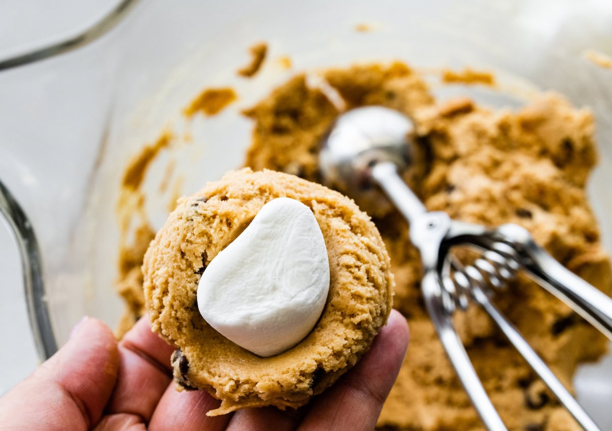 stuffing a biscoff s'mores cookie with a marshmallow.