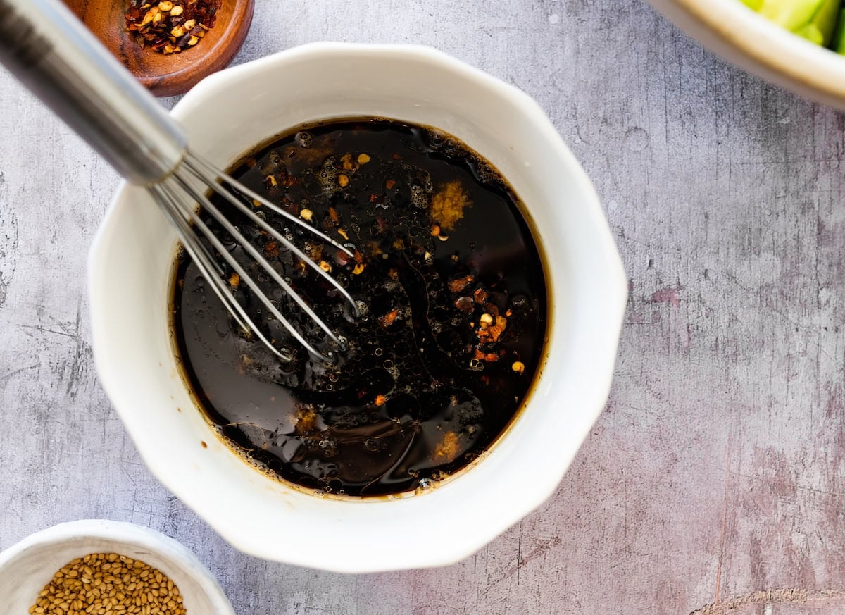 soy ginger dressing in bowl with whisk.