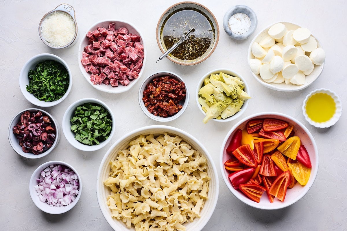 ingredients in bowls to make Italian pasta salad.