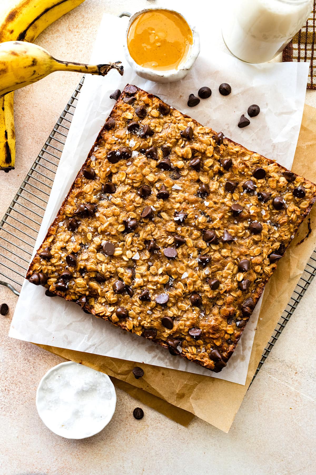peanut butter banana oatmeal bars with chocolate chips and flaky sea salt on cooling rack.