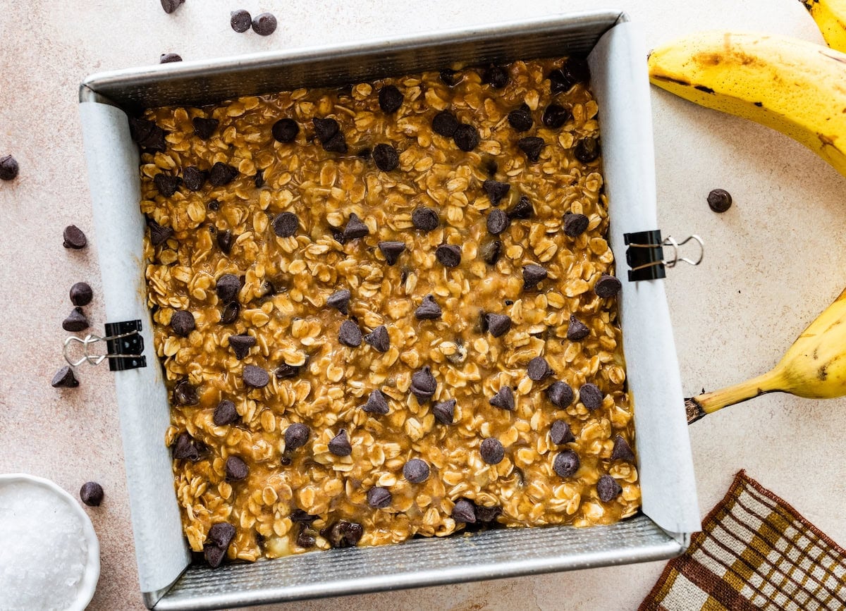 peanut butter banana oatmeal bars in pan with chocolate chips on top ready to be baked.