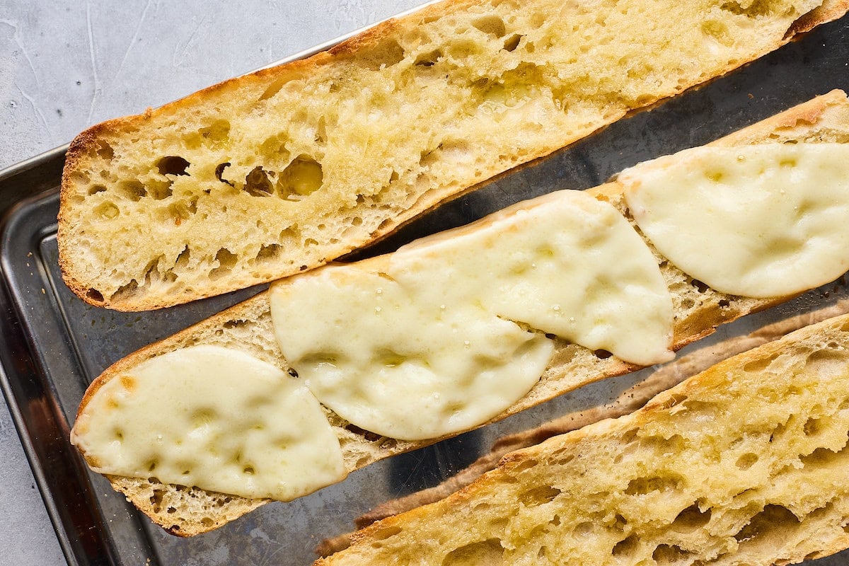 melted provolone cheese on toasted baguette.