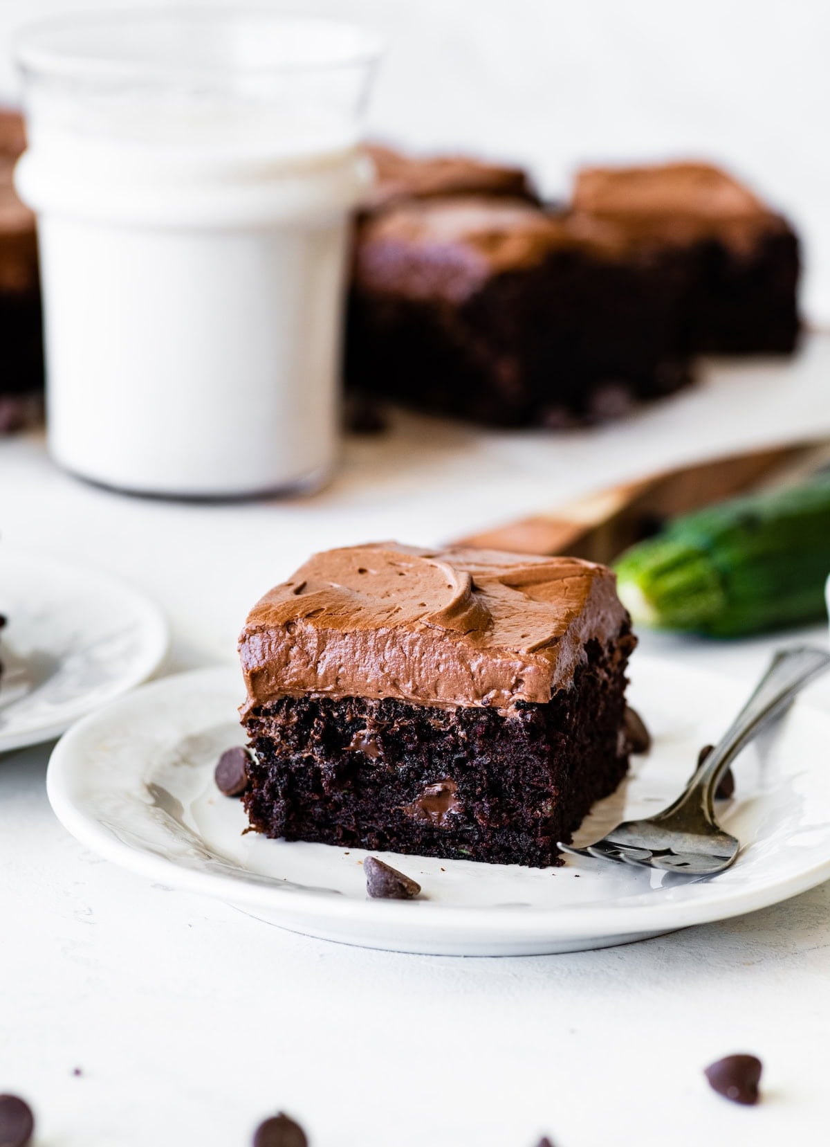 piece of chocolate zucchini cake on plate with fork.