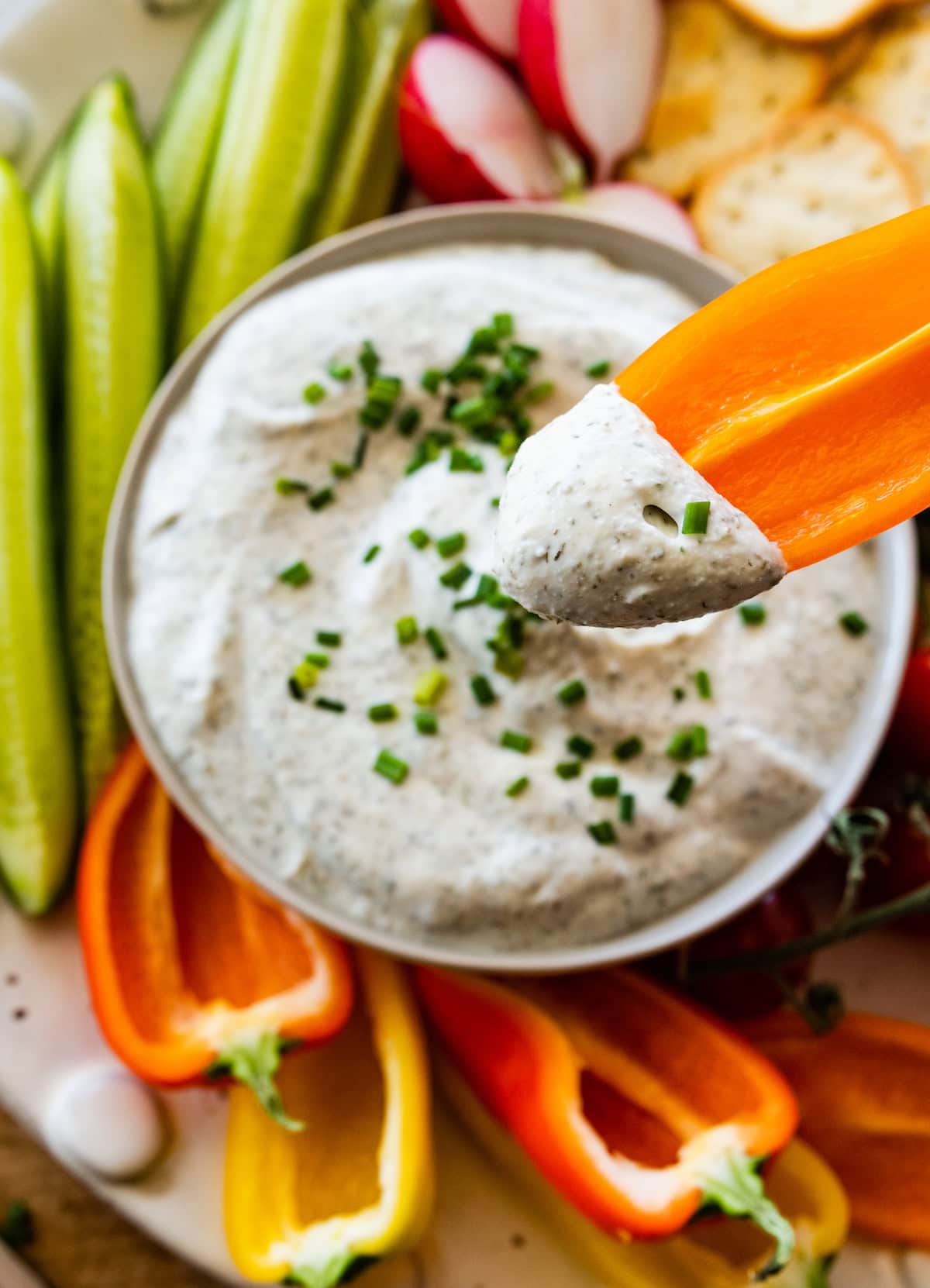 bell pepper being dipped into homemade ranch dip.