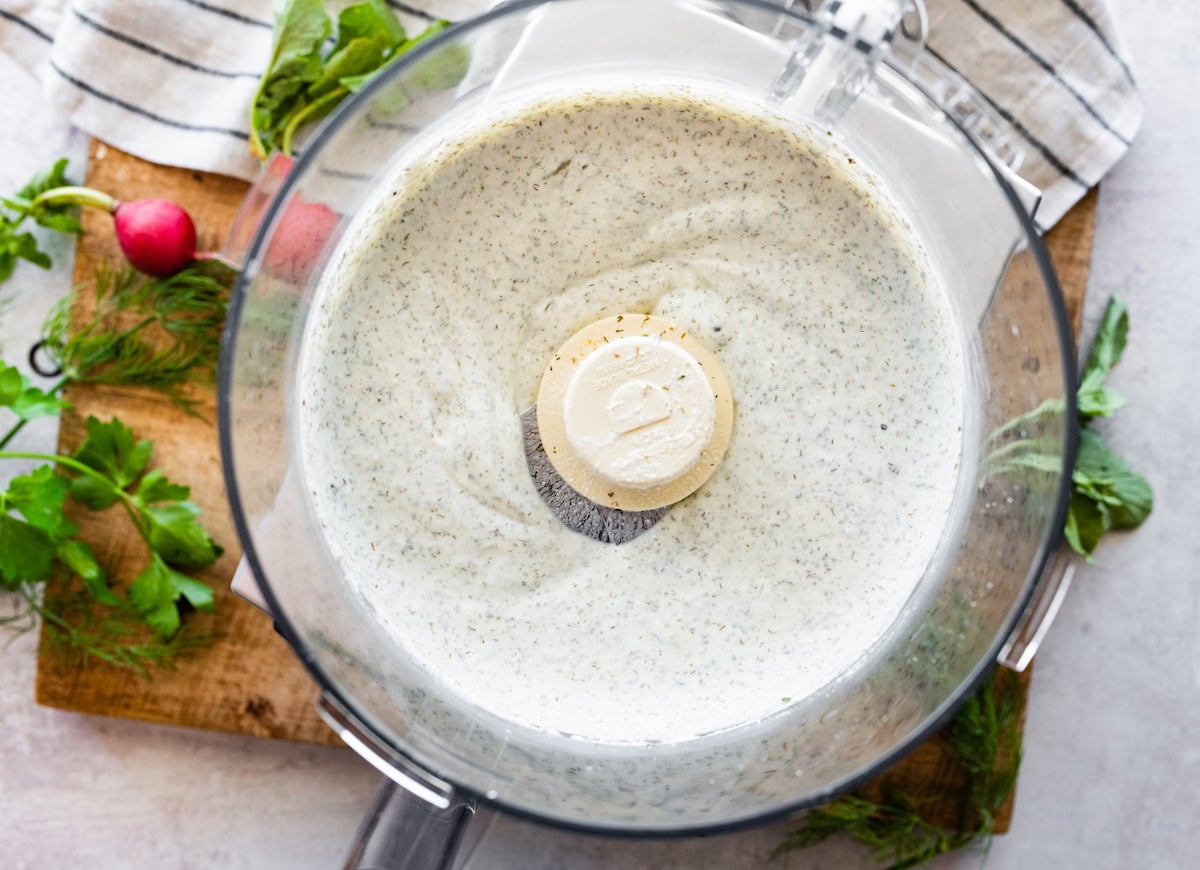 homemade ranch dip being blended in food processor bowl.
