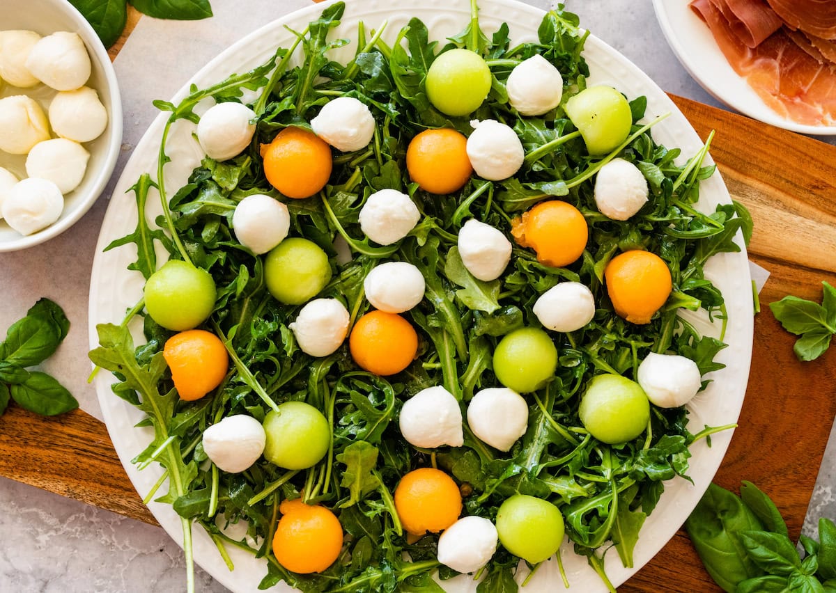 arugula with melon balls and fresh mozzarella balls.