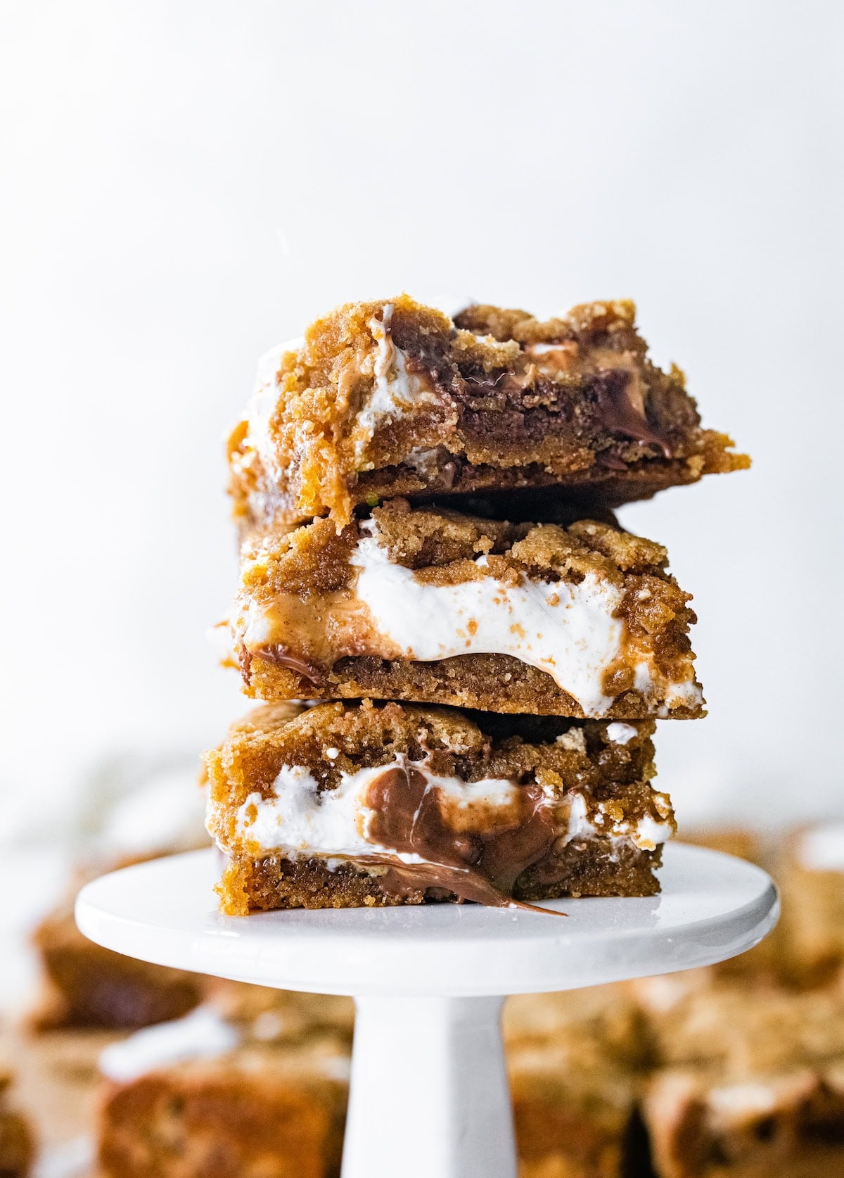 stack of peanut butter s'mores bars on mini cake stand.