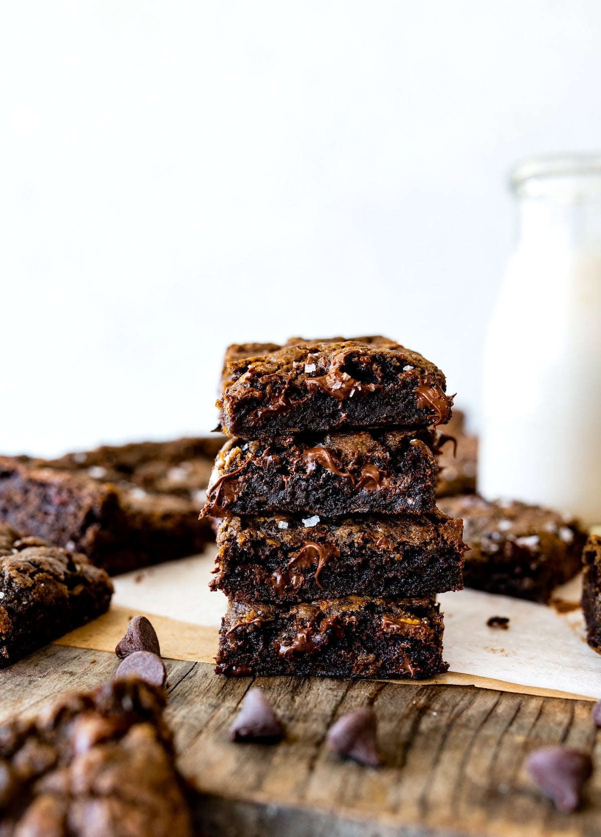 stack of zucchini brownies with bottle of milk.