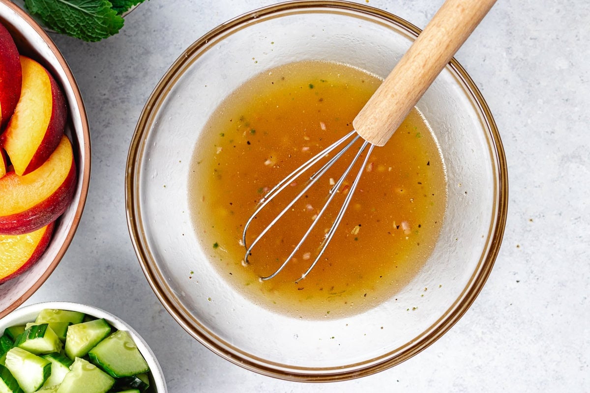 honey lime dressing in bowl with whisk.