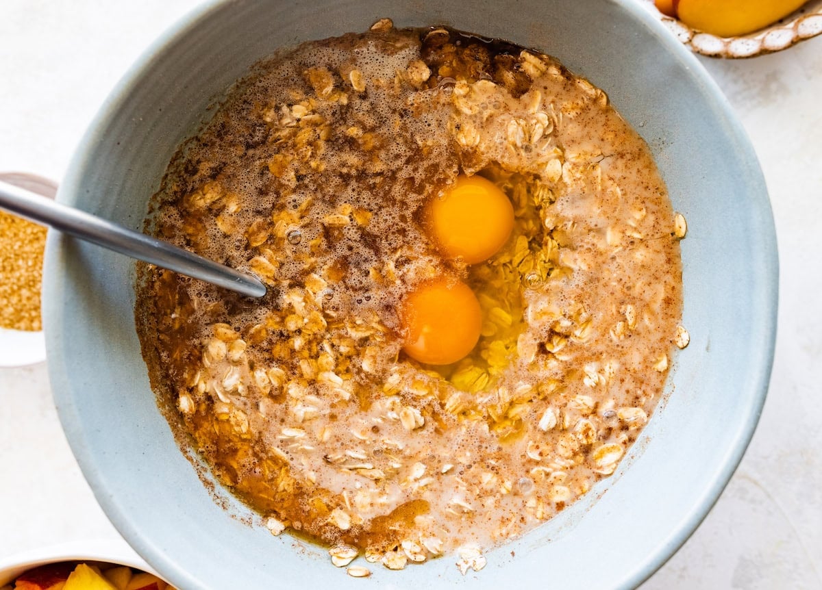 baked oatmeal mixture in mixing bowl with spoon.