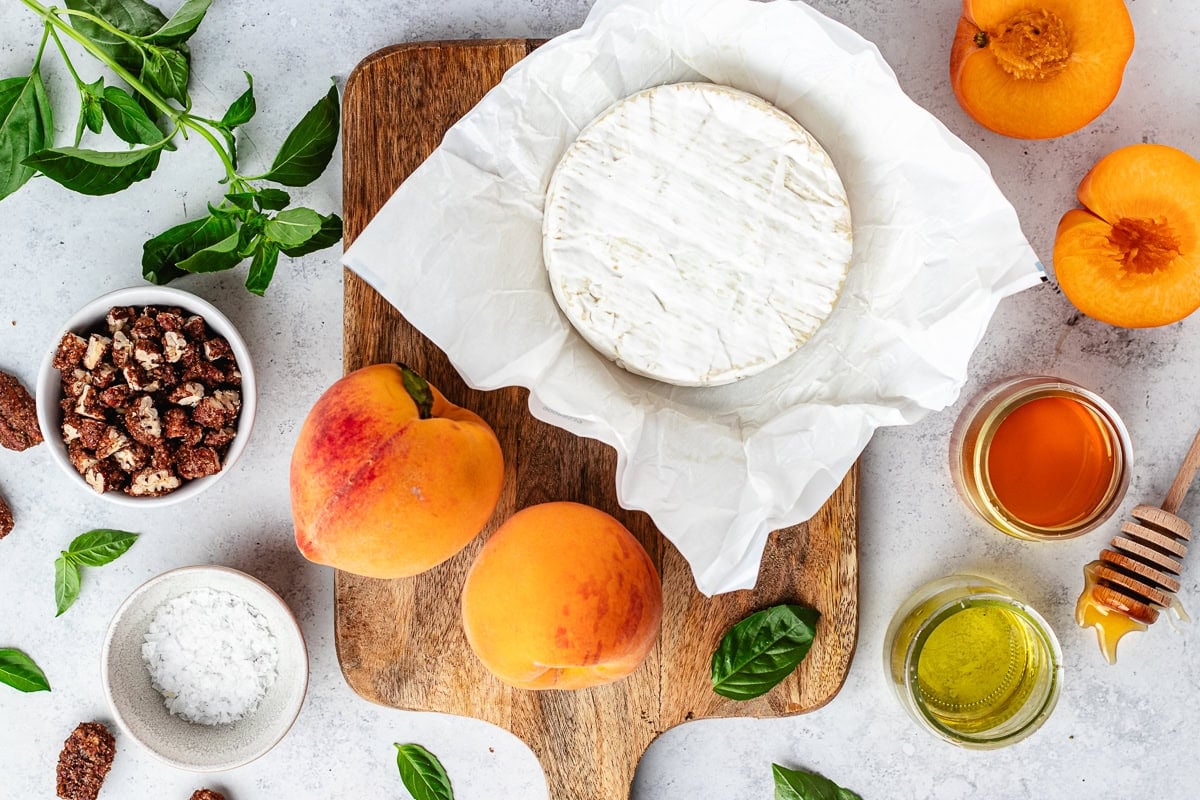 ingredients on wood board to make grilled brie with peaches.