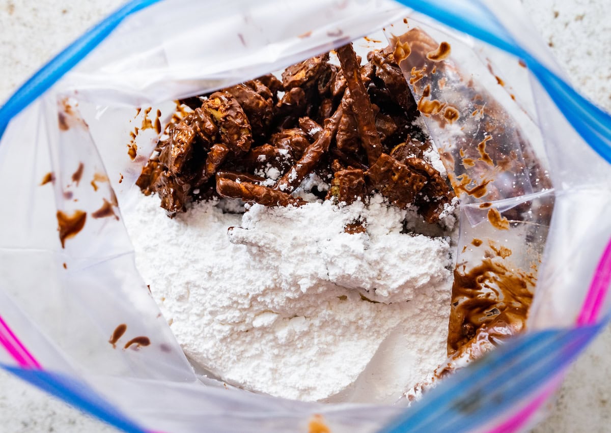 sweet and salty puppy chow in ziploc bag with powdered sugar.
