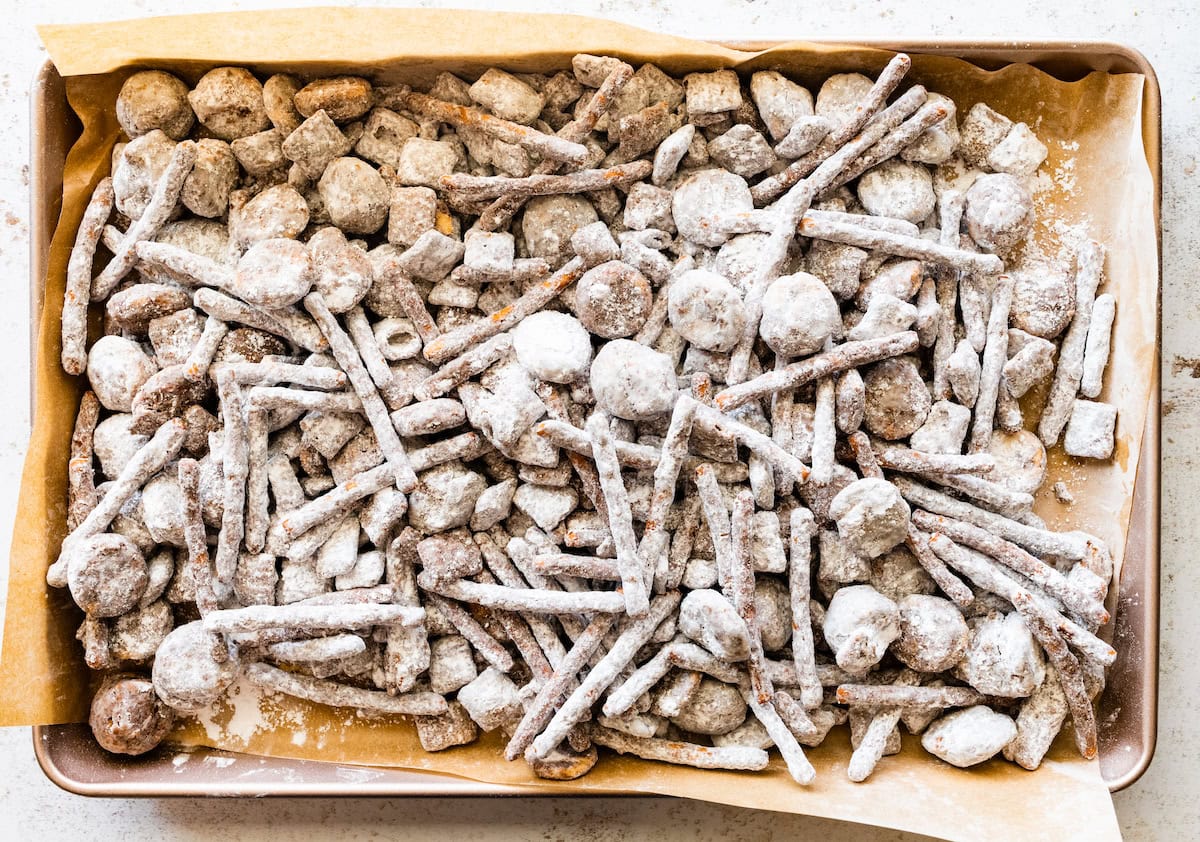 sweet and salty puppy chow on baking sheet lined with parchment paper.