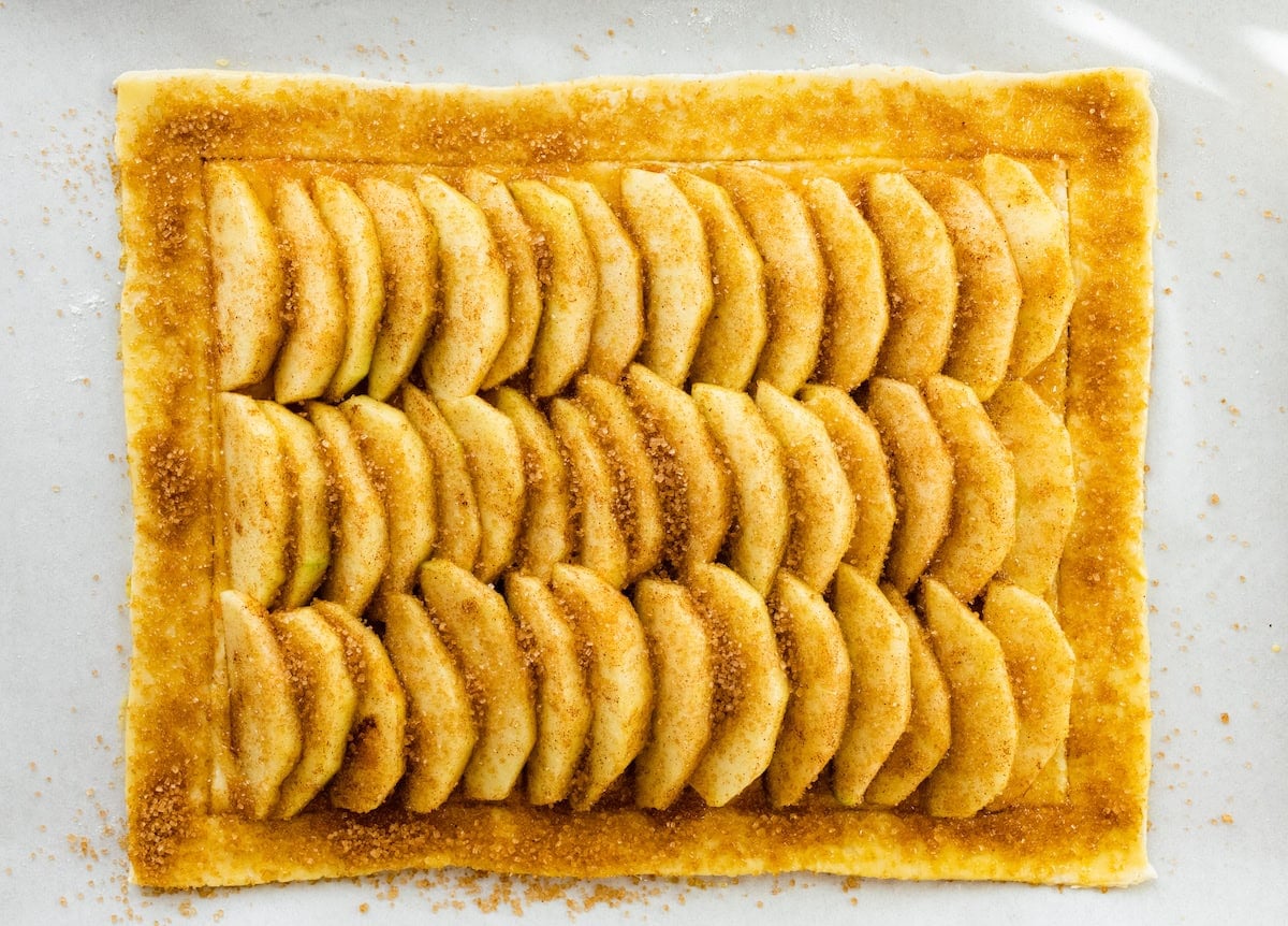 apple slices on top of puff pastry with turbinado sugar.
