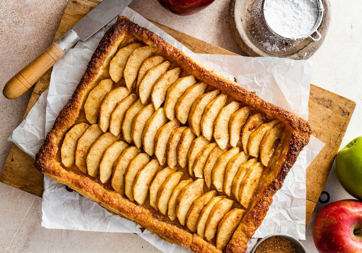 puff pastry apple tart on wood board with parchment paper.