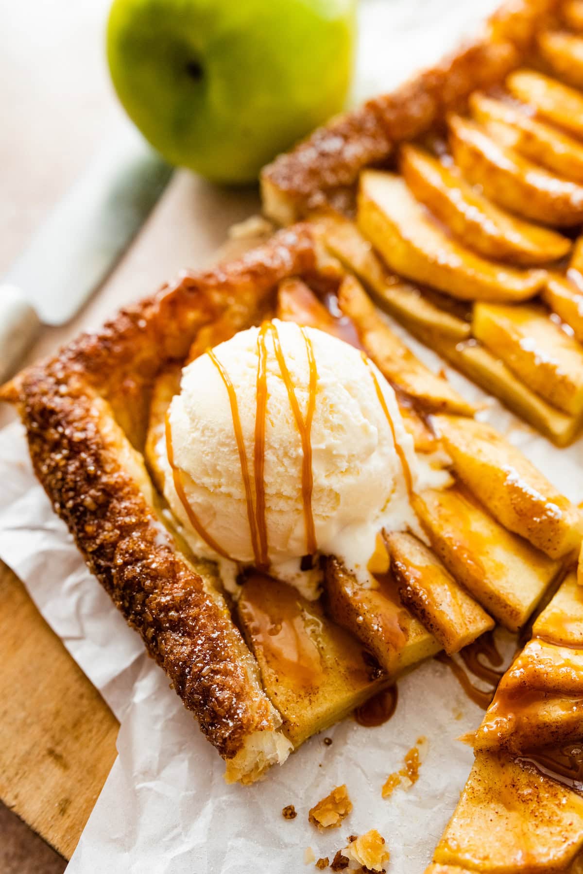 piece of puff pastry apple tart with scoop of vanilla ice cream and salted caramel sauce.