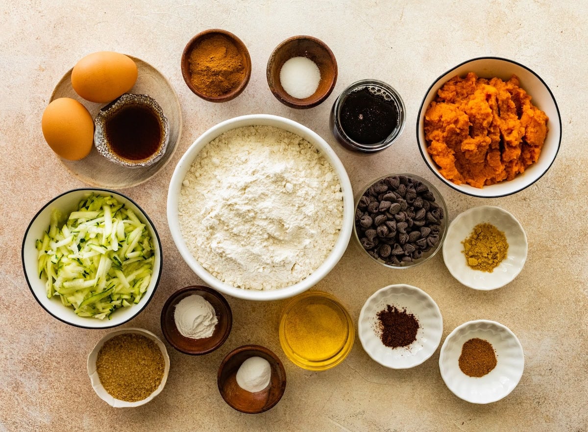 ingredients in bowls to make pumpkin zucchini muffins.