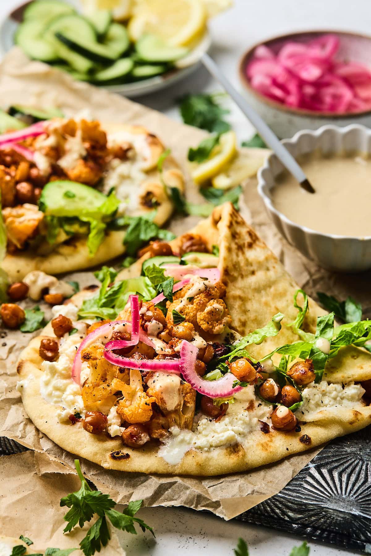 roasted cauliflower chickpea wraps with tahini dressing and pickled red onions.