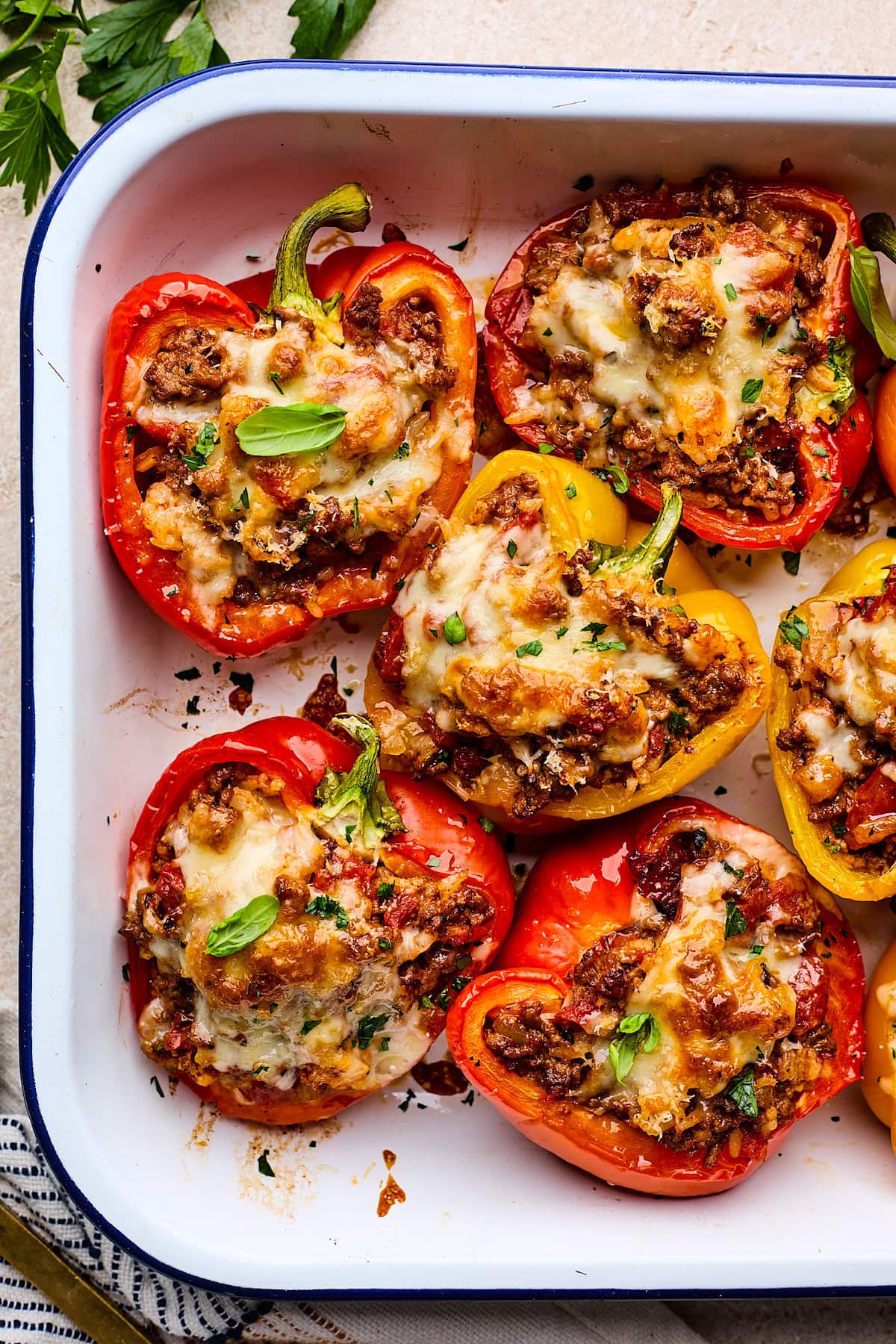 stuffed bell peppers in pan with cheese and herbs.