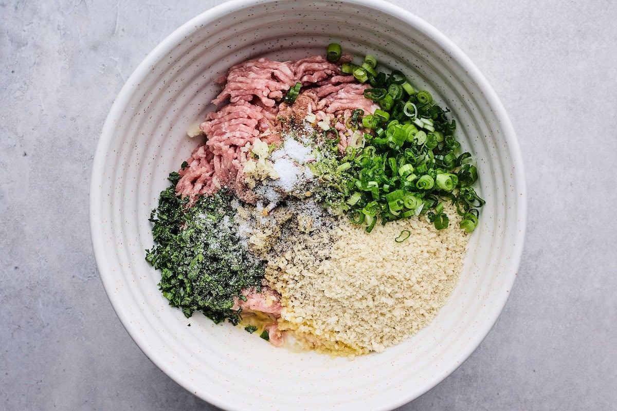 ground turkey, panko, egg, garlic, ginger, green onion, herbs in bowl to make soy ginger meatballs.