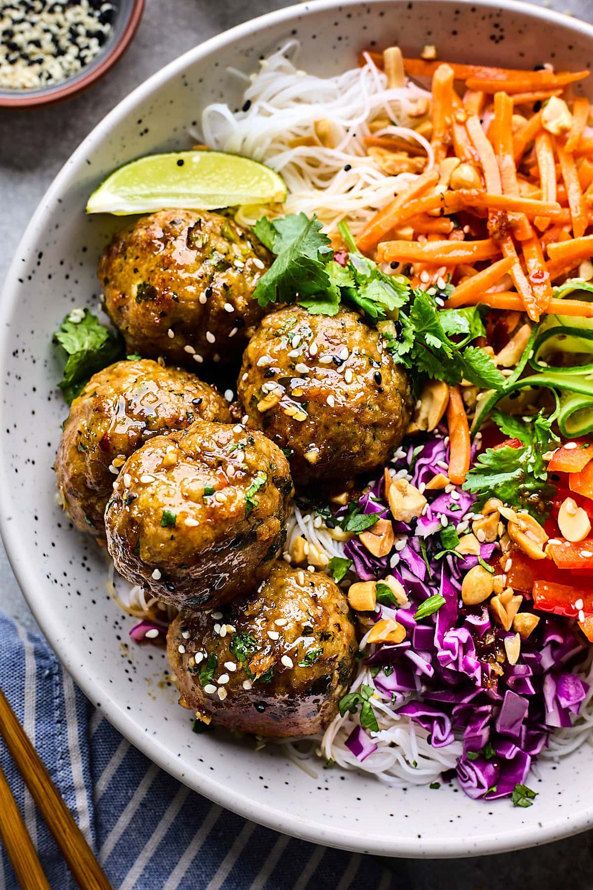 Asian noodle bowl with soy ginger meatballs, noodles, and fresh vegetables.