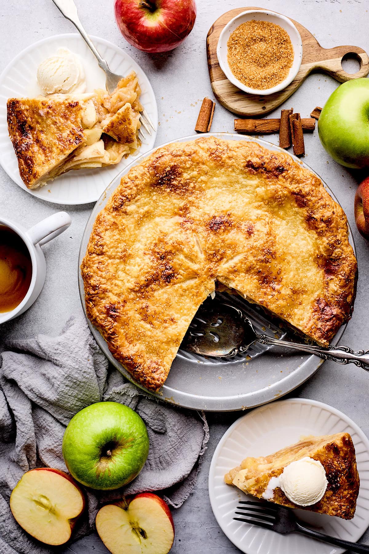 apple pie with 2 pieces of pie on plates with ice cream.