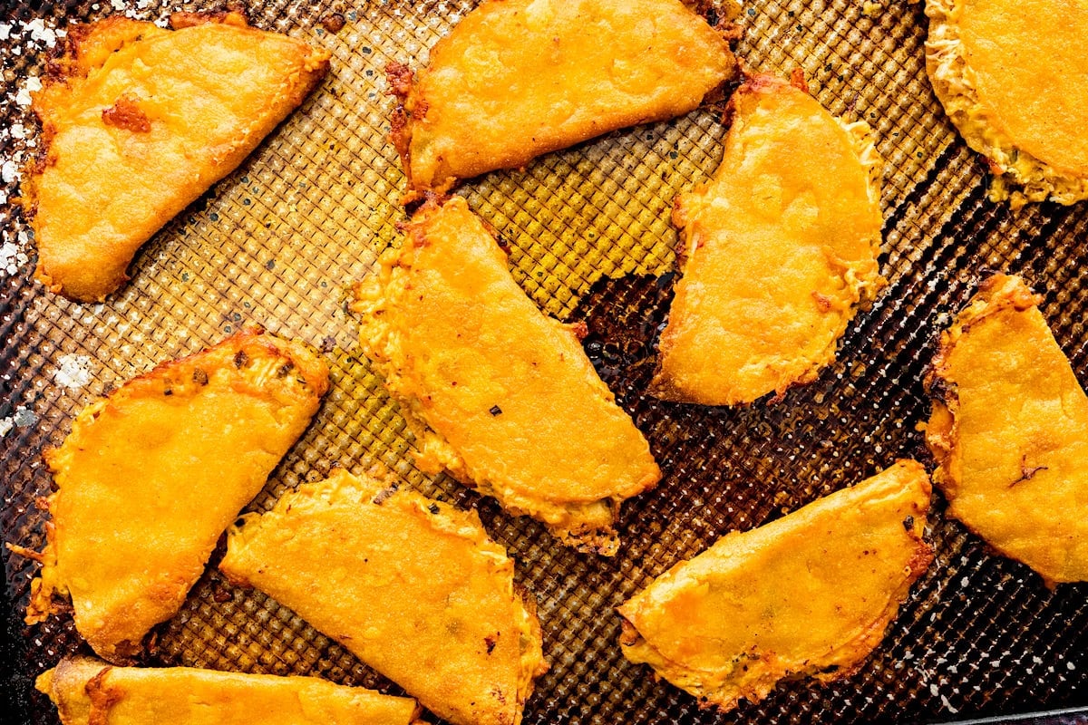 crispy buffalo chicken tacos on baking sheet.