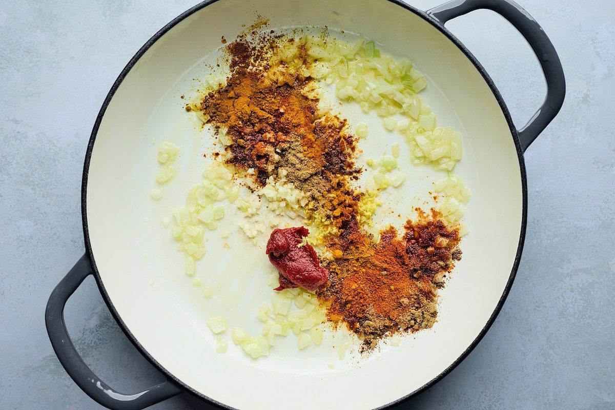 onion, garlic, spices, and tomato paste in pot to make tikka masala meatballs.