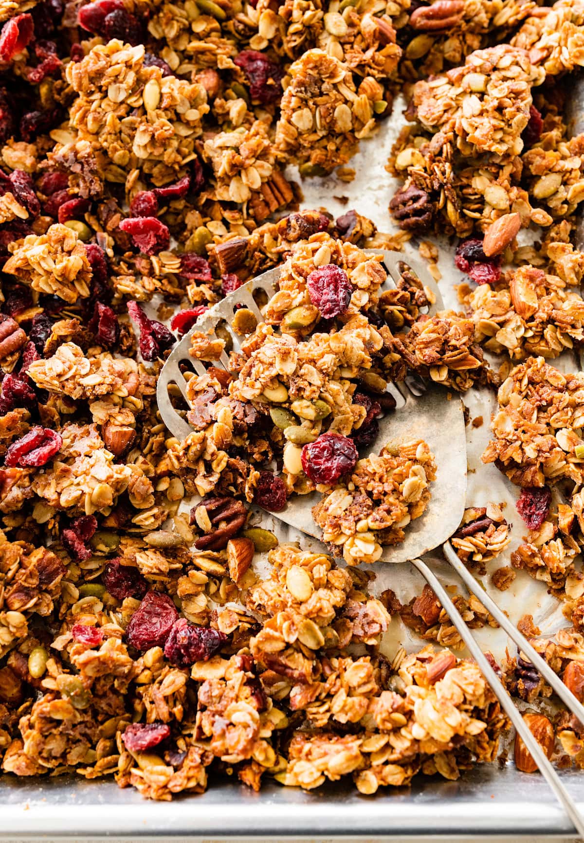 granola on baking sheet with spatula.