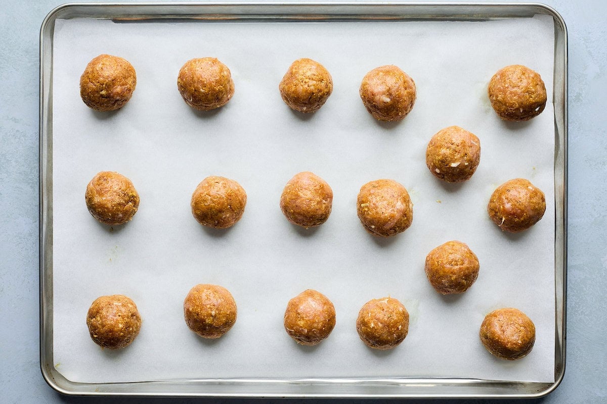 tikka masala meatballs on baking sheet with parchment paper.