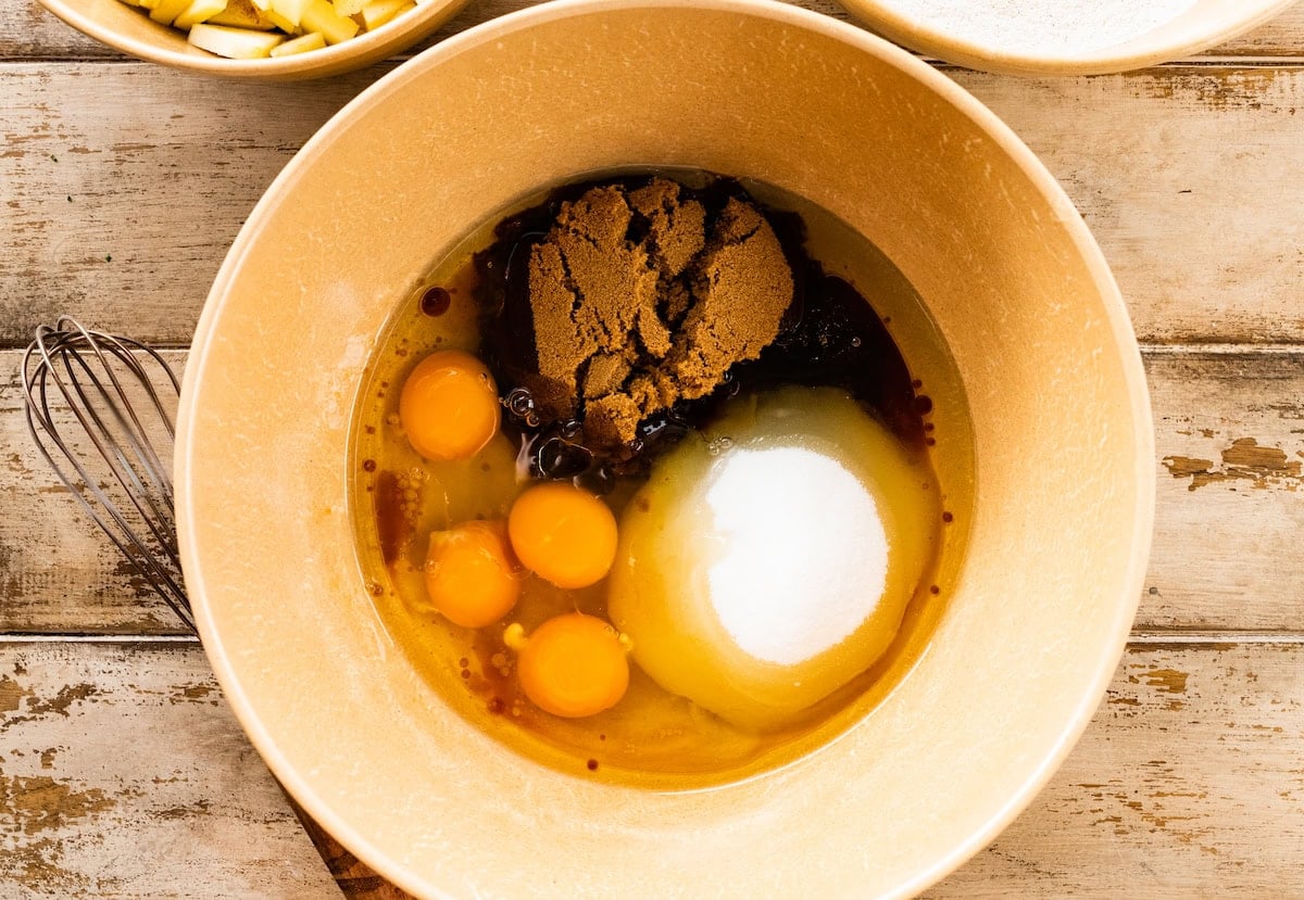 sugars, oil, eggs, and vanilla in mixing bowl to make apple cake.