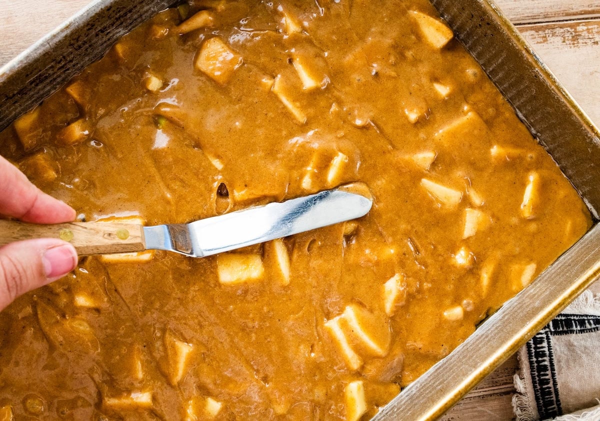 apple cake batter being spread in pam.