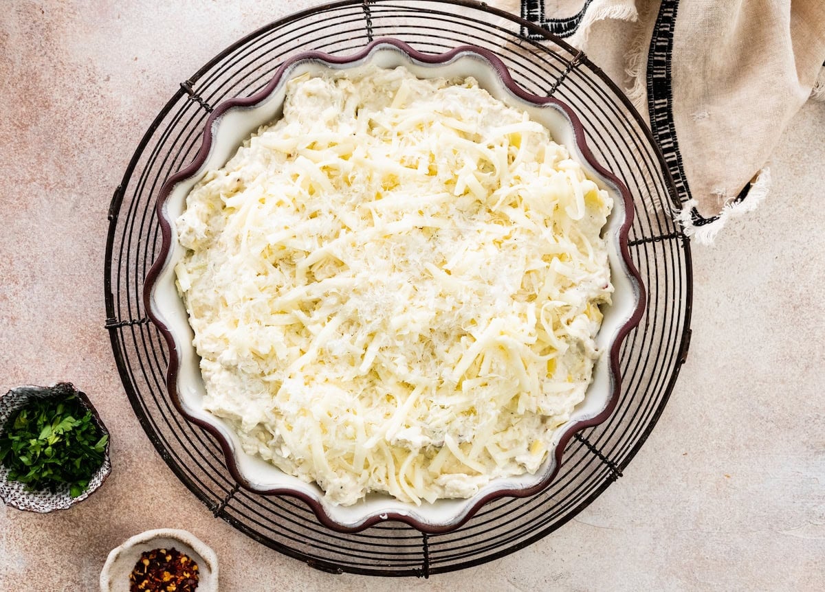 artichoke dip in baking dish with cheese on top.
