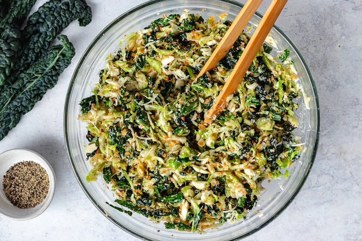 Brussels Sprouts Kale Caesar Salad in bowl with toasted breadcrumbs and Caesar dressing.