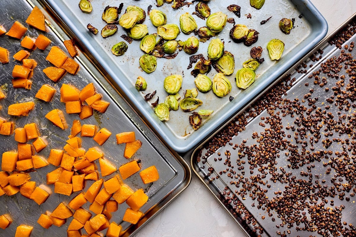 roasted butternut squash, roasted brussels sprouts, and crispy lentils on baking sheets.