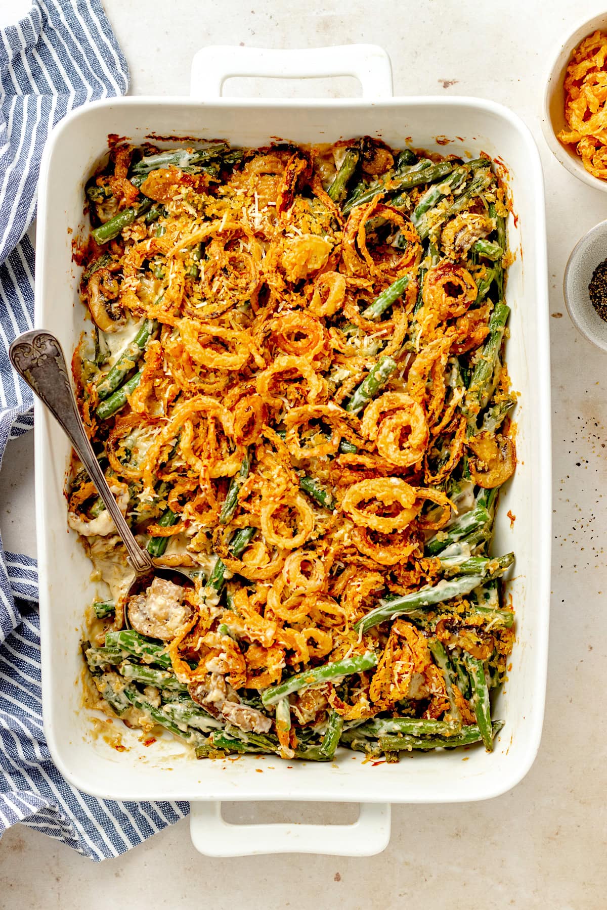 green bean casserole with crispy fried onions in baking dish.