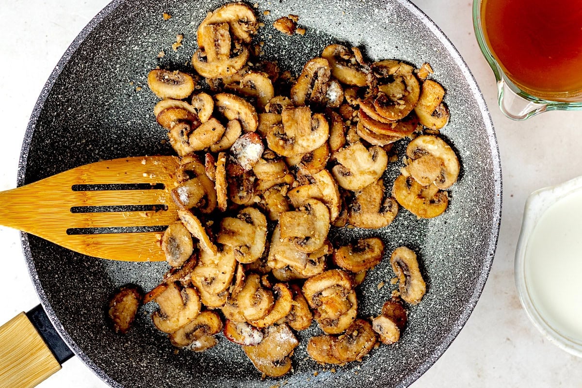 mushrooms cooking in skillet.