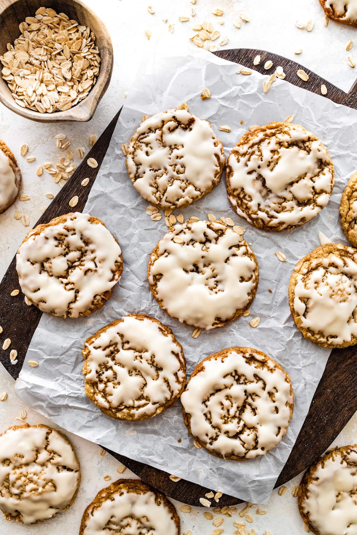 iced oatmeal cookies on parchment paper.