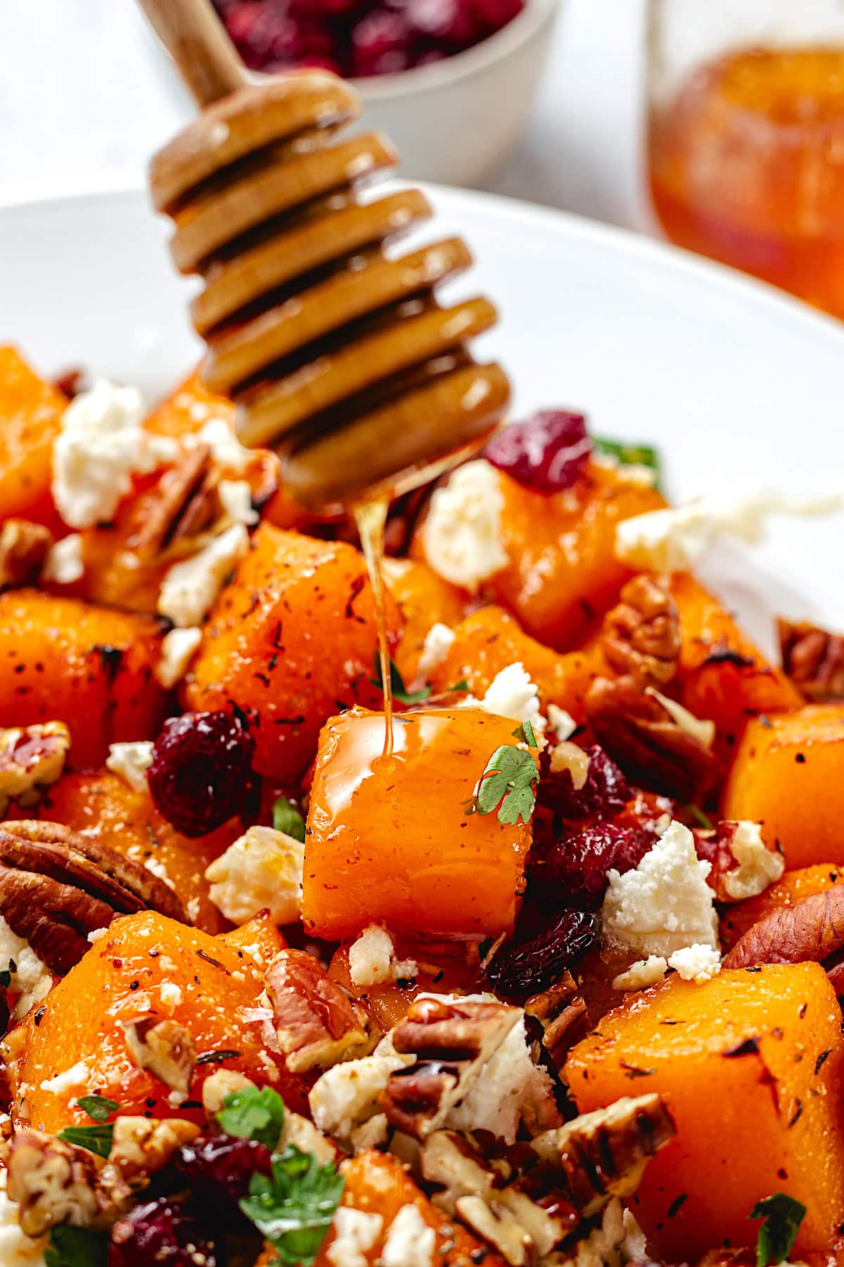 hot honey being drizzled over roasted butternut squash.