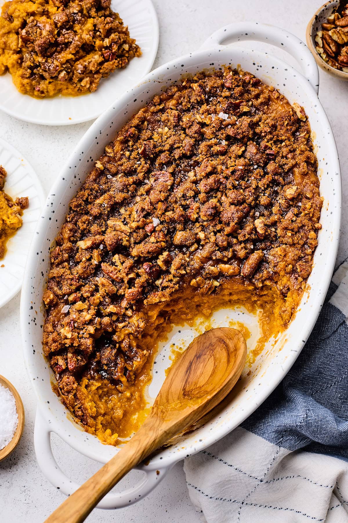 sweet potato casserole in baking dish with wooden spoon.