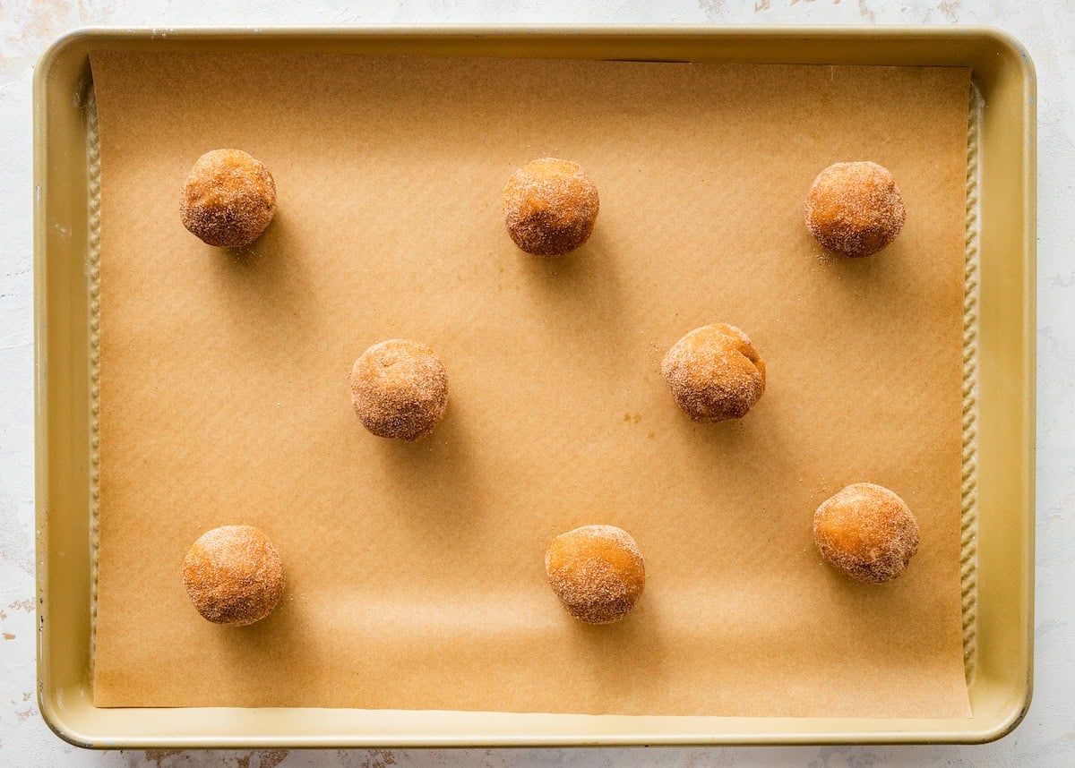 Brown Butter White Chocolate Candied Pecan Cookie dough balls on baking sheet with parchment paper.