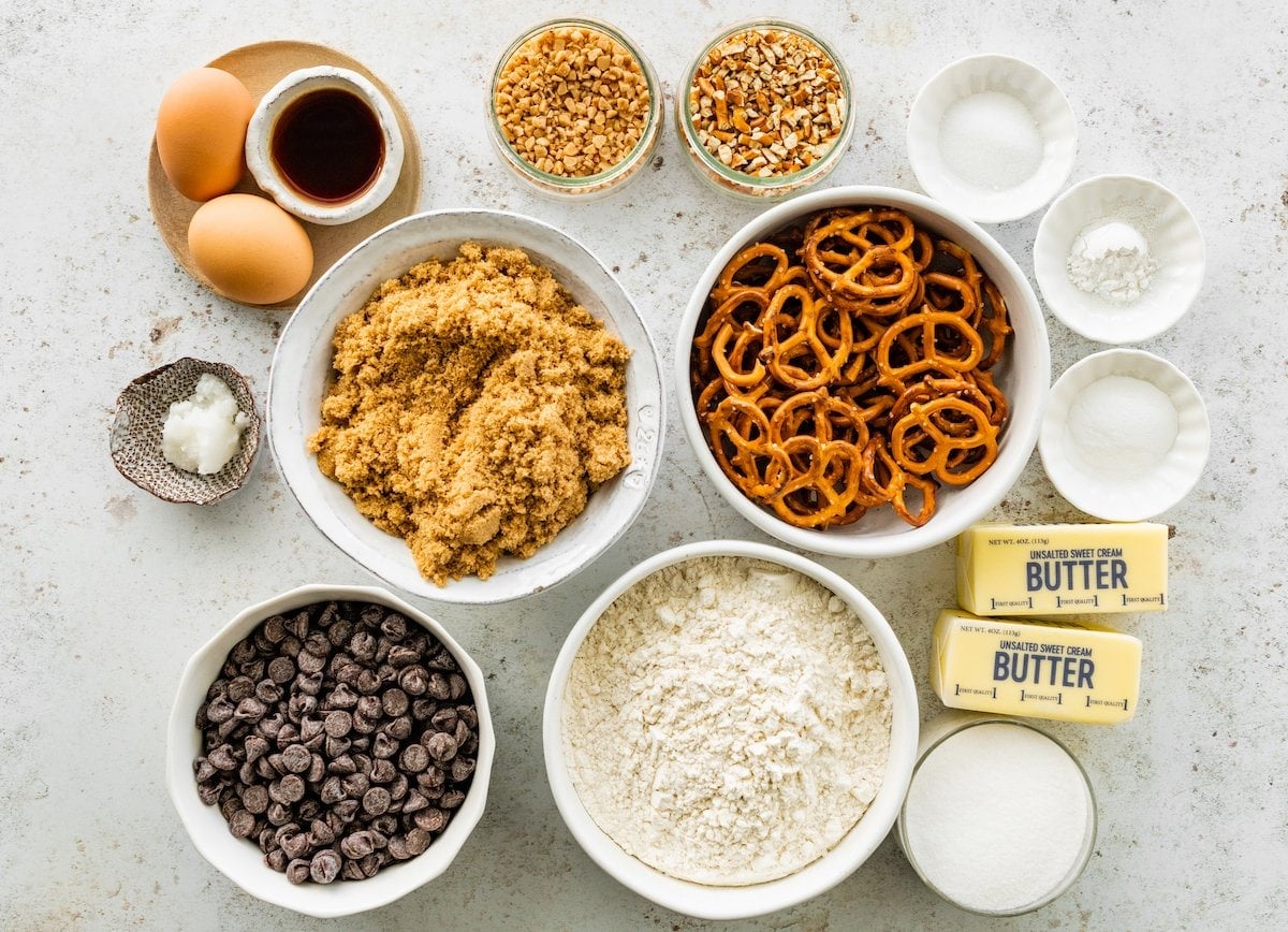 ingredients in bowls to make chocolate dipped pretzel cookies.