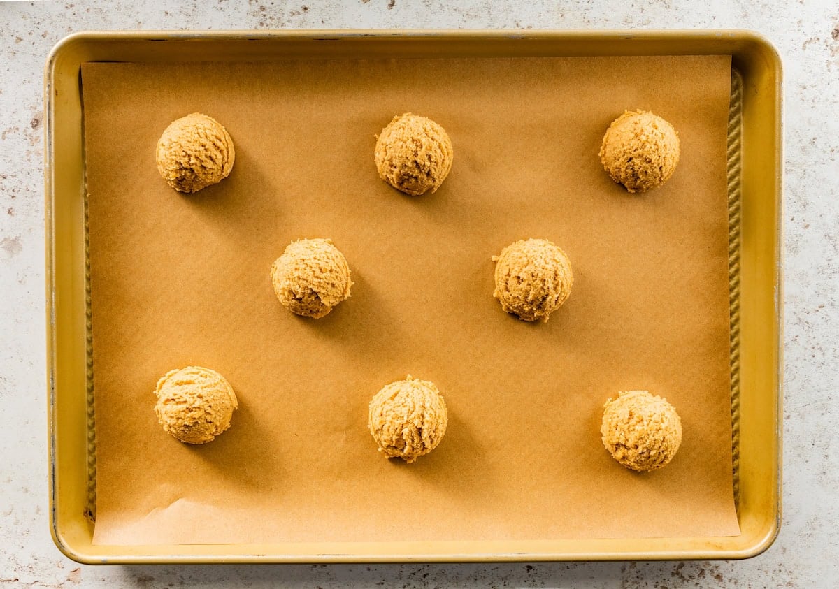 pretzel cookie dough balls on baking sheet with parchment paper.